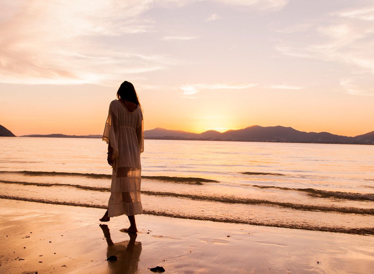 Woman iIn White Dress Walking On Beach