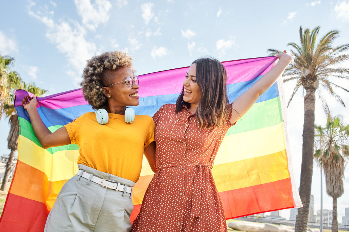 Diverse LGBTQ Couple Holding a Pride Flag